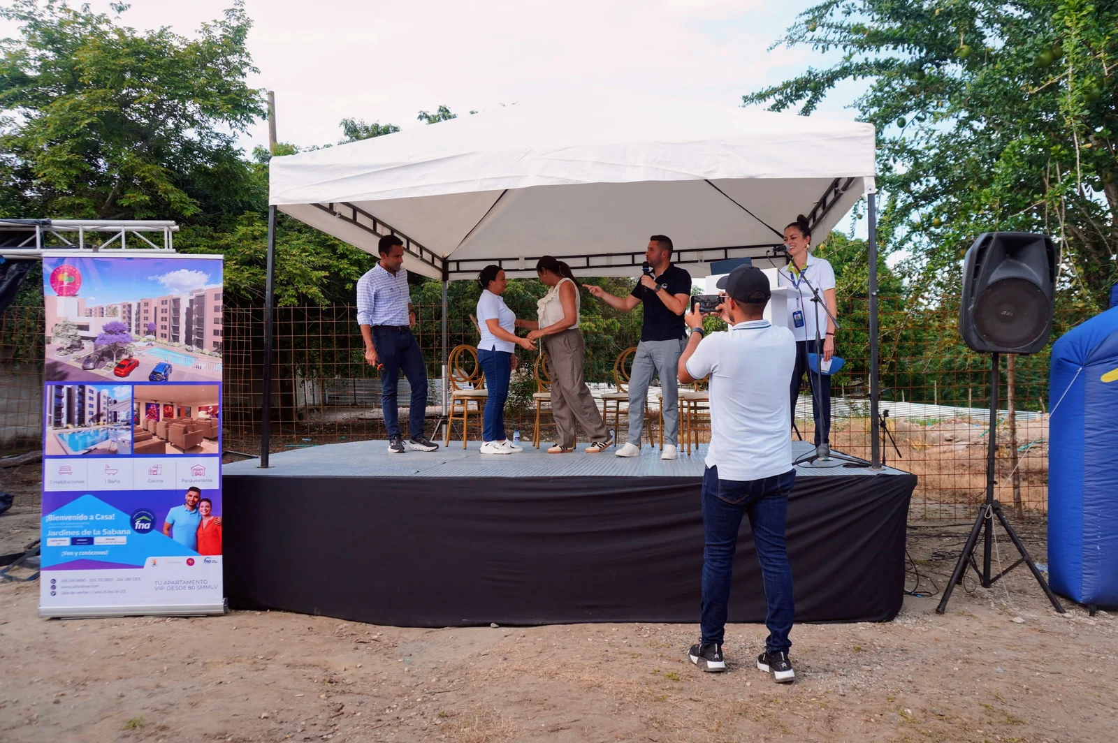 Tarima del acto de lanzamiento de Jardines de la Sabana, junto al pendón del proyecto, durante la jornada con el Fondo Nacional del Ahorro.