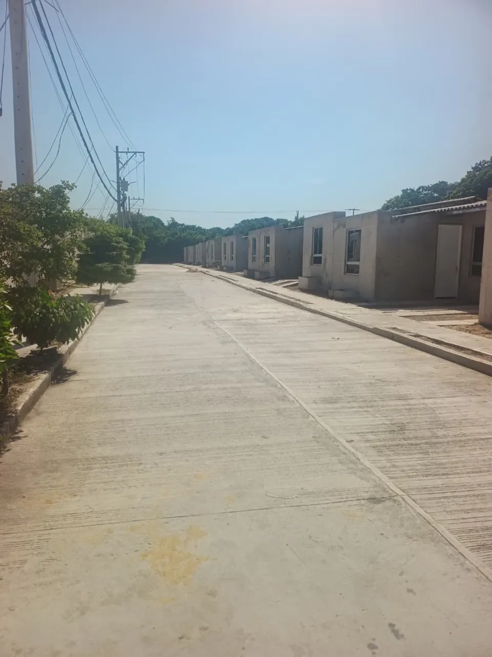 Calle pavimentada de San Antonio con casas en construcción al fondo.